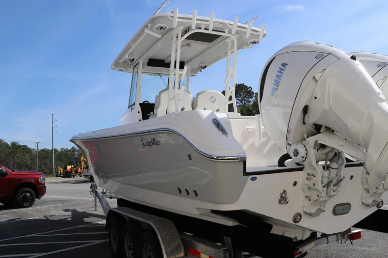 Slide: The Image of 2025 Edgewater 325CC boat with dual Yamaha outboard engines, docked outdoors. - 4
