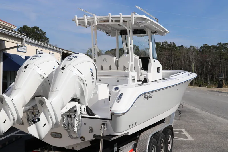 Slide: The Image of 2025 Edgewater 325CC boat on trailer with dual Yamaha engines, parked outdoors. - 5