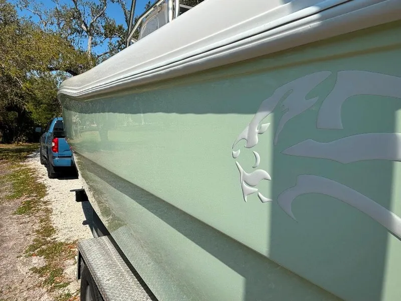 Slide: The Image of 2023 Prowler 25 boat with sleek design and logo, parked on a trailer. - 10