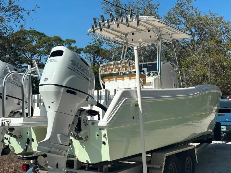 Slide: The Image of 2023 Prowler 25 boat with Suzuki outboard motor on trailer, parked outdoors. - 3