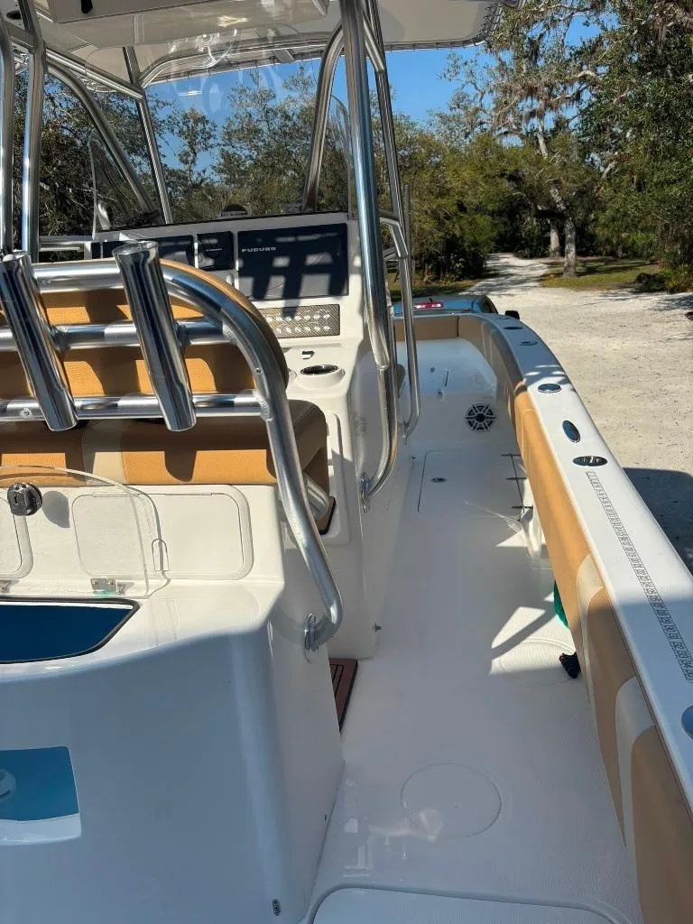 Slide: The Image of 2023 Prowler 25 boat interior with modern controls and seating, docked outdoors. - 37