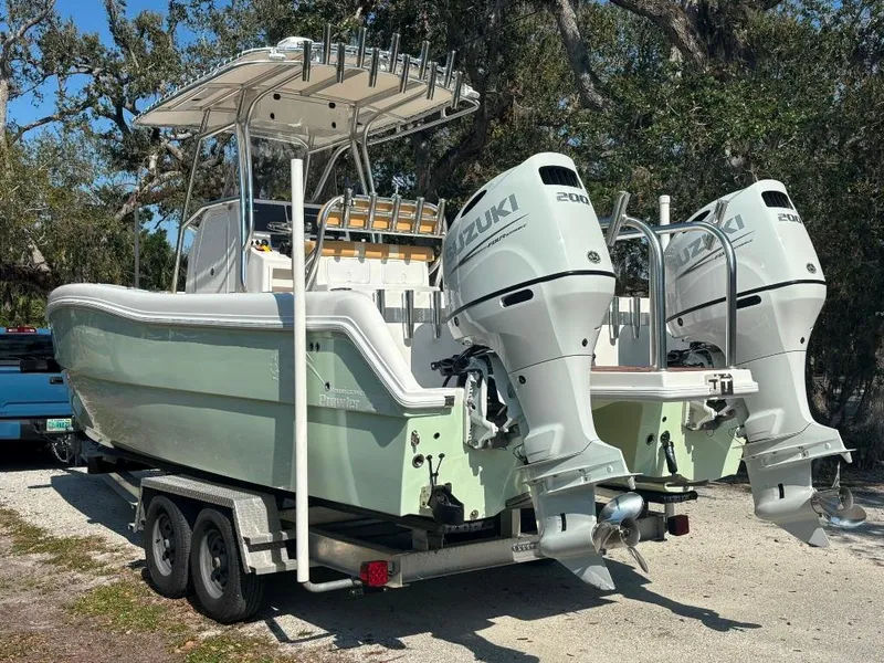 Slide: The Image of 2023 Prowler 25 boat with dual Suzuki engines on a trailer, parked outdoors. - 4