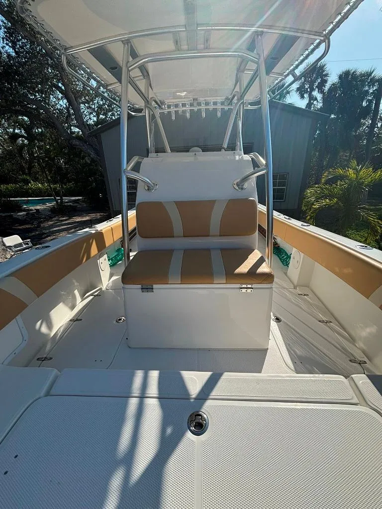 Slide: The Image of 2023 Prowler 25 boat interior with tan and white seating, outdoor setting. - 41
