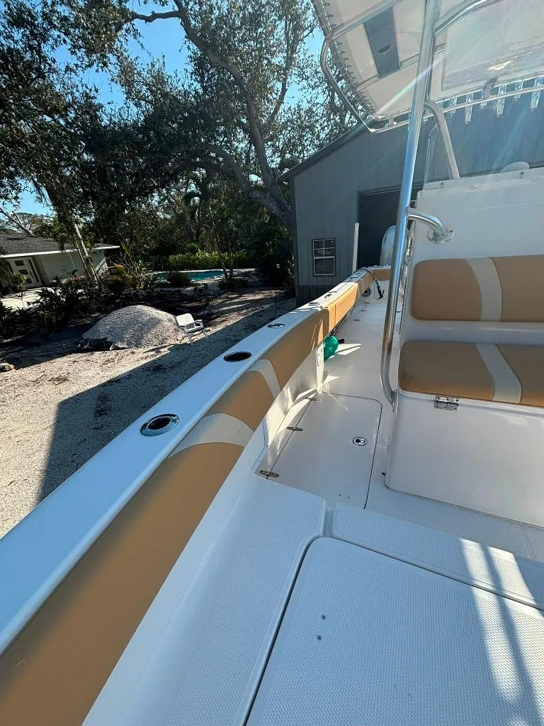 Slide: The Image of 2023 Prowler 25 boat interior with tan and white seating, docked outdoors. - 42