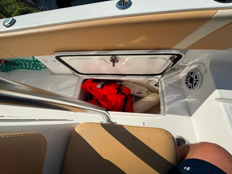 Slide: The Image of Storage compartment on 2023 Prowler 25 boat with life jackets and beige seating. - 43