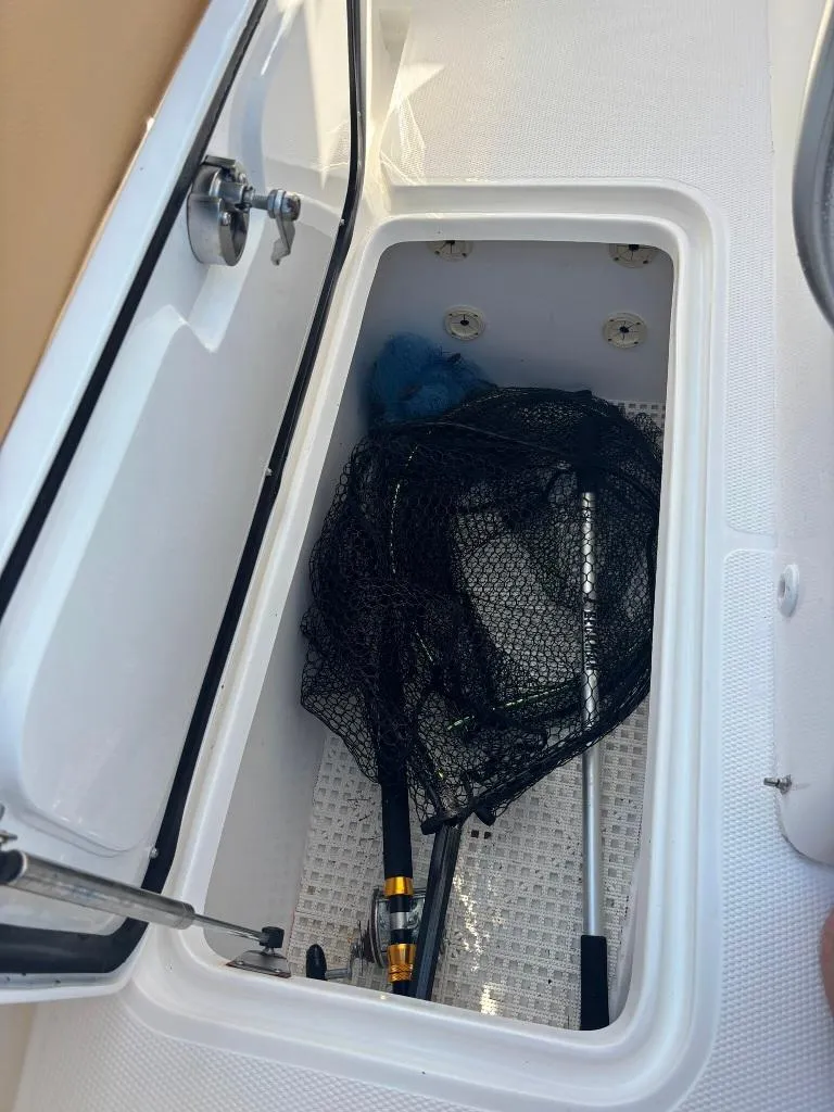 Slide: The Image of Storage compartment on 2023 Prowler 25 boat with fishing gear inside. - 45