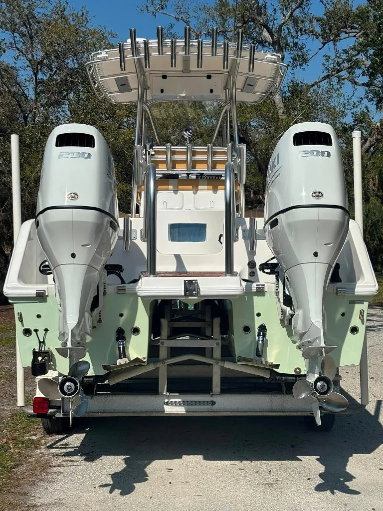 Slide: The Image of 2023 Prowler 25 boat with dual outboard engines, rear view, parked outdoors. - 5