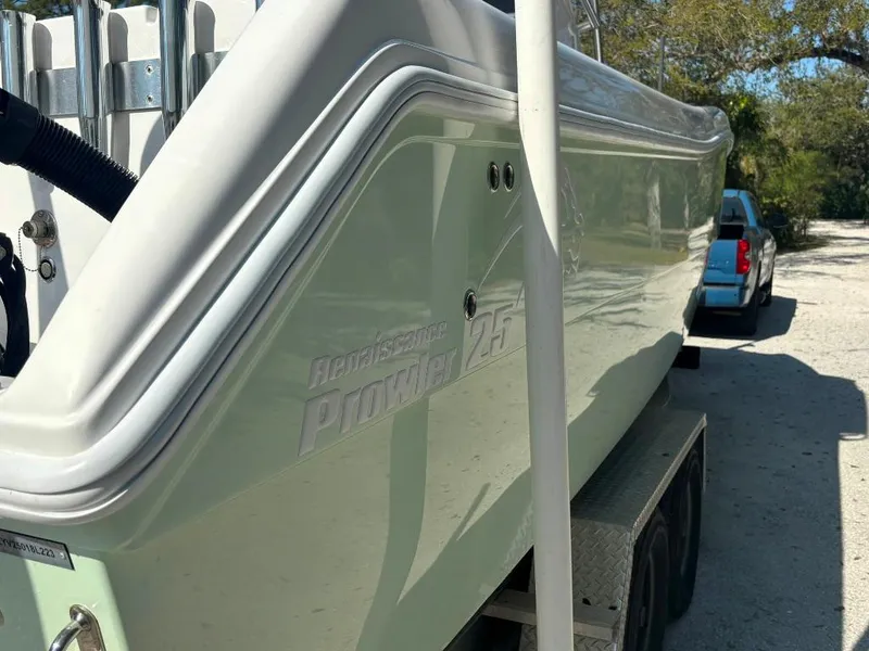 Slide: The Image of 2023 Prowler 25 boat on trailer, side view, parked outdoors. - 9
