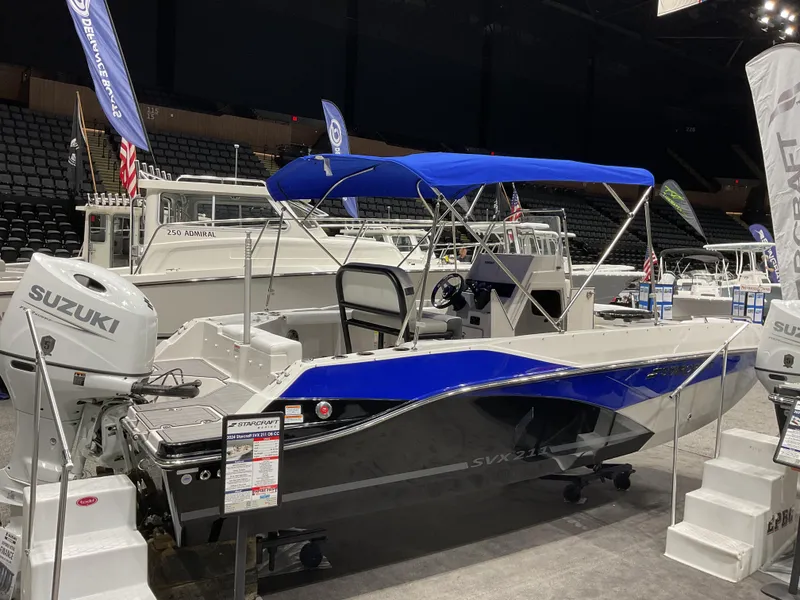 Slide: The Image of 2025 Starcraft SVX 211 OB CC boat with Suzuki engine, displayed indoors. - 17