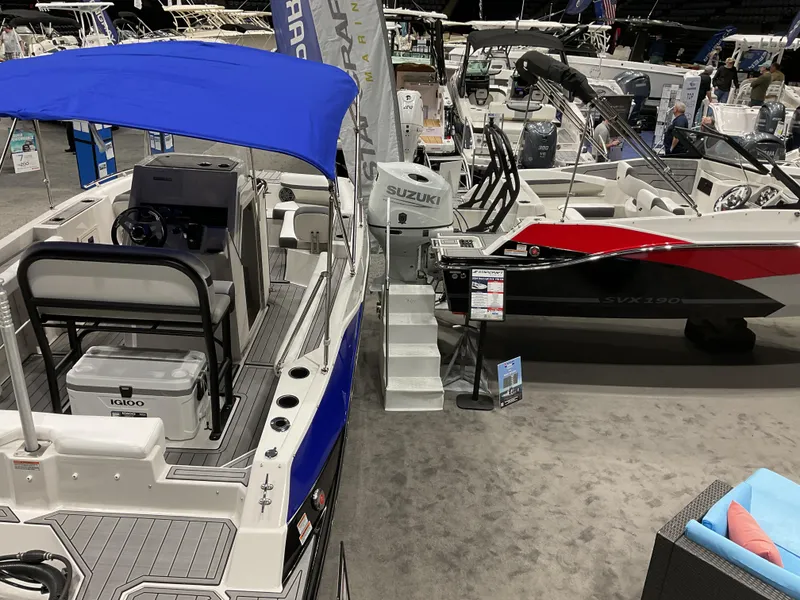Slide: The Image of 2025 Starcraft SVX 211 OB CC boat with blue canopy at indoor exhibition. - 19
