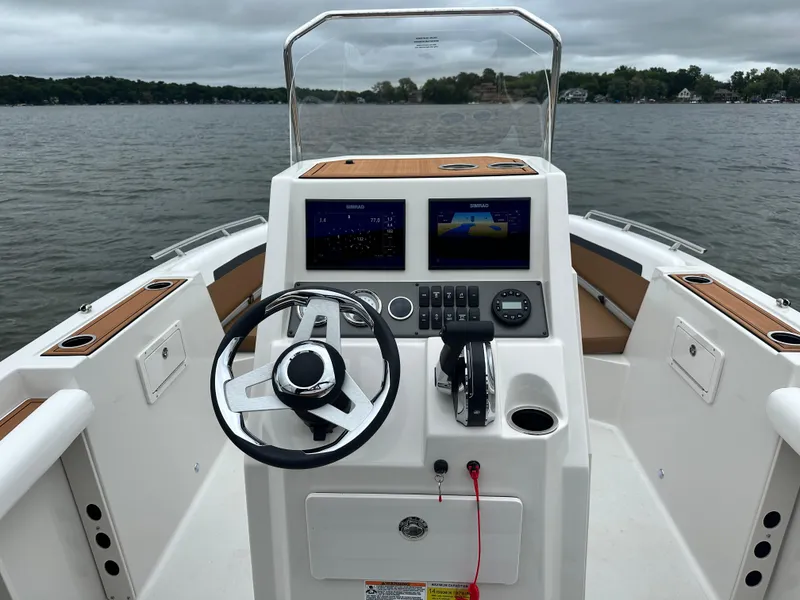 Slide: The Image of 2025 Starcraft SVX 211 OB CC boat dashboard with dual screens on a lake. - 23