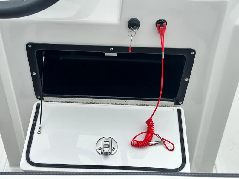 Slide: The Image of 2025 Starcraft SVX 211 OB CC boat console with storage compartment and safety lanyard. - 25