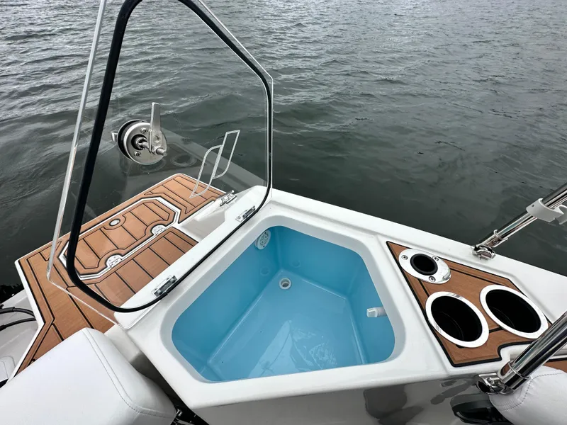Slide: The Image of 2025 Starcraft SVX 211 OB CC boat with open hatch and cup holders on deck. - 28