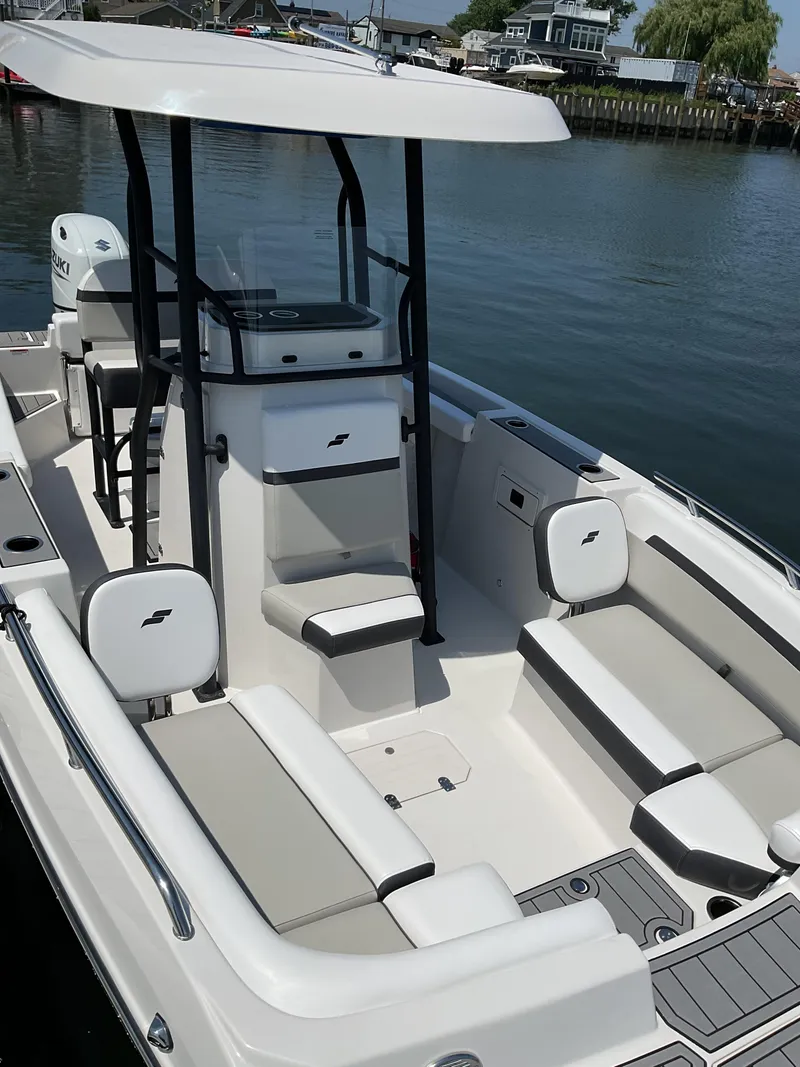 Slide: The Image of 2025 Starcraft SVX 211 OB CC boat with seating, docked on calm water. - 3