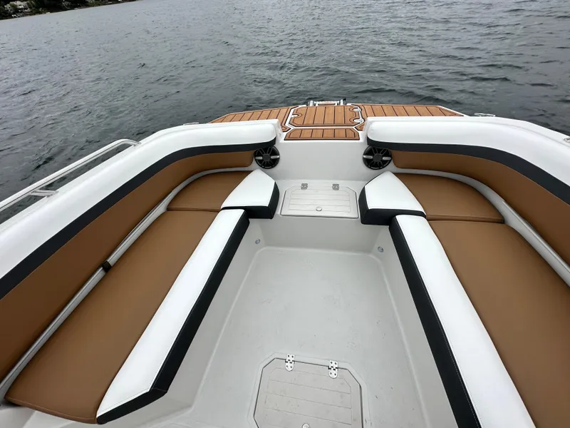 Slide: The Image of 2025 Starcraft SVX 211 OB CC boat interior with tan and white seating on the water. - 31