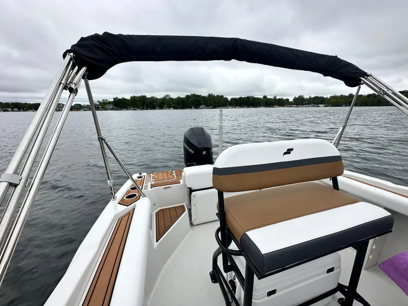 Slide: The Image of 2025 Starcraft SVX 211 OB CC boat interior with seating, on a calm lake. - 32