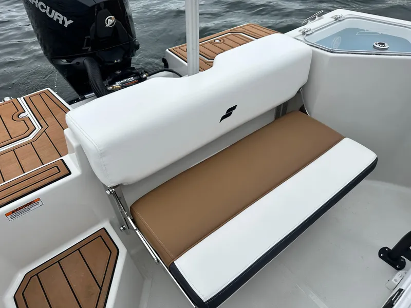 Slide: The Image of 2025 Starcraft SVX 211 OB CC boat interior with cushioned seating and Mercury outboard motor. - 34