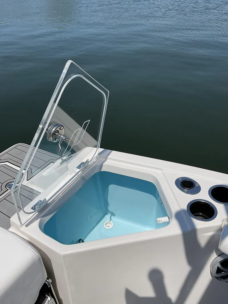 Slide: The Image of 2025 Starcraft SVX 211 OB CC boat with open storage compartment on calm water. - 6