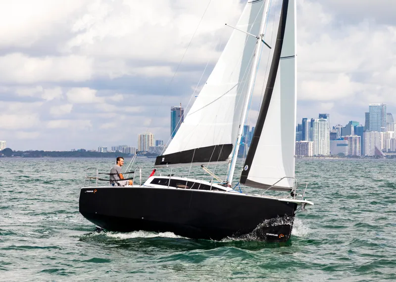 Slide: The Image of 2025 Maxus 26 sailboat cruising near city skyline on a sunny day. - 3