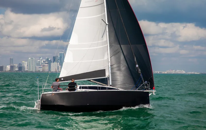 Slide: The Image of 2025 Maxus 26 sailboat on open water with city skyline in background. - 8
