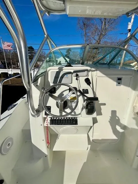 Slide: The Image of 2008 Sailfish 218 WAC boat cockpit with steering wheel and controls, American flag in background. - 11
