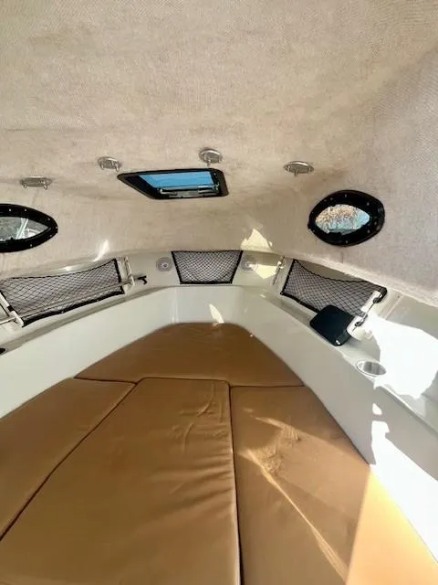 Slide: The Image of Interior cabin of 2008 Sailfish 218 WAC boat with tan cushions and portholes. - 17