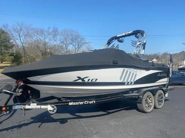 Slide: The Image of 2013 MasterCraft X-10 boat on trailer, covered, parked outdoors. - 2