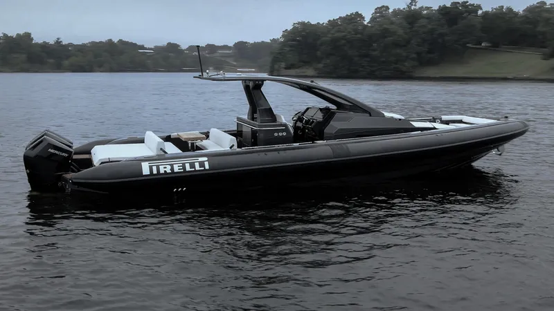 Slide: The Image of 2024 Pirelli 42 OB boat on calm water, sleek design, overcast sky. - 2