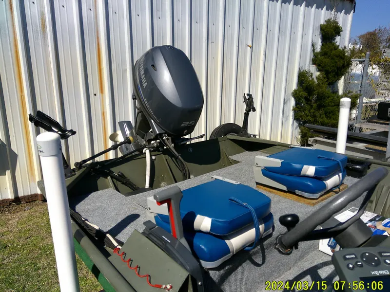 Slide: The Image of 2018 Alumacraft 1648 Jon boat with motor and blue cushions, parked outdoors. - 5