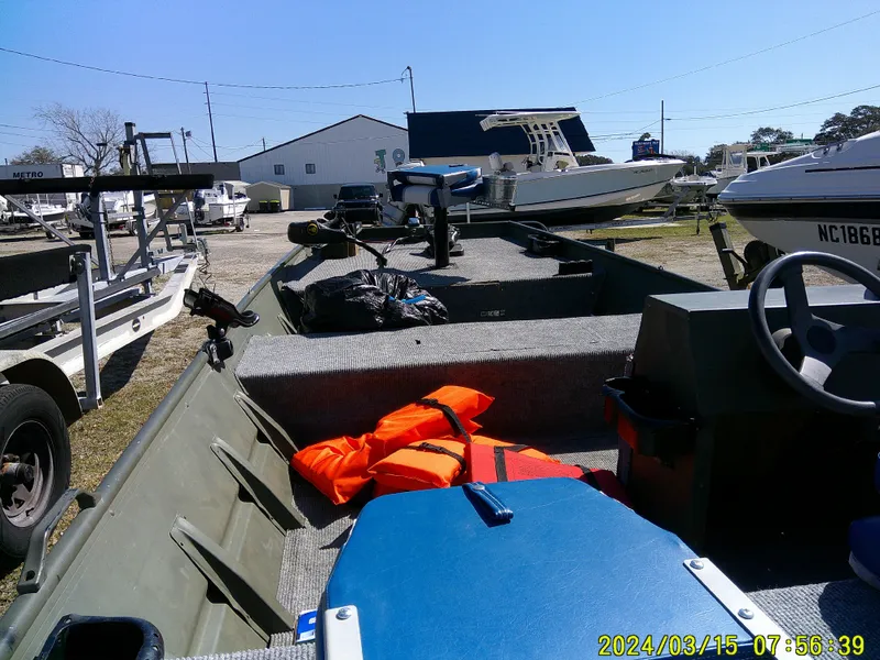 Slide: The Image of 2018 Alumacraft 1648 Jon boat with life jackets and equipment, parked outdoors. - 8