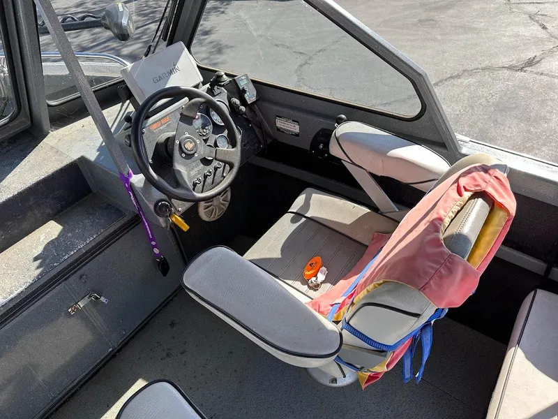 Slide: The Image of Interior of a 2000 North River 19 Sportster boat with steering wheel and seat. - 24