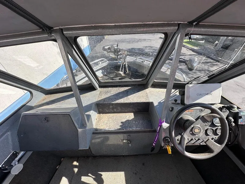 Slide: The Image of Interior view of a 2000 North River 19 Sportster boat cockpit with steering wheel and Garmin device. - 26