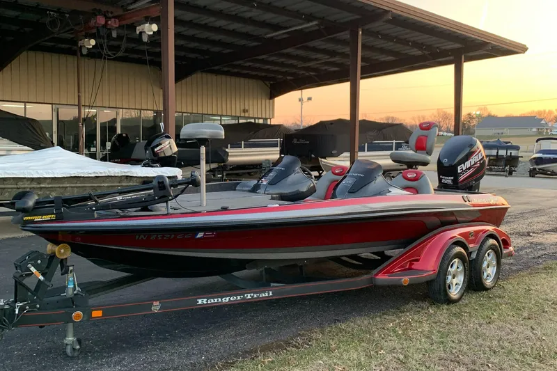 Slide: The Image of 2006 Ranger Z20 Comanche boat on trailer, parked under a metal canopy at sunset. - 2