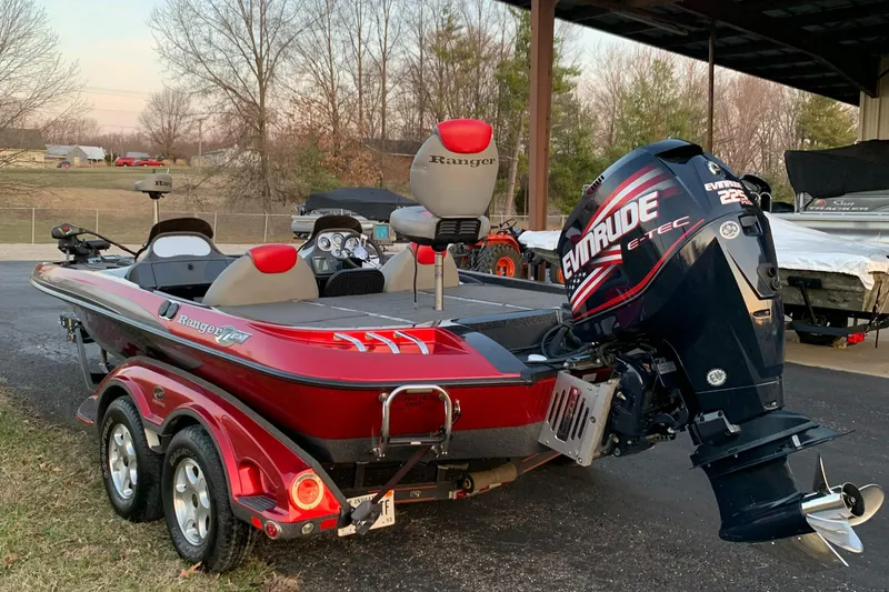 Slide: The Image of 2006 Ranger Z20 Comanche boat with Evinrude engine, parked outdoors. - 3