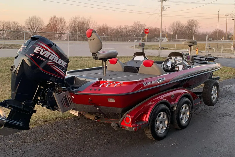 Slide: The Image of 2006 Ranger Z20 Comanche boat with Evinrude engine on trailer, parked outdoors. - 4