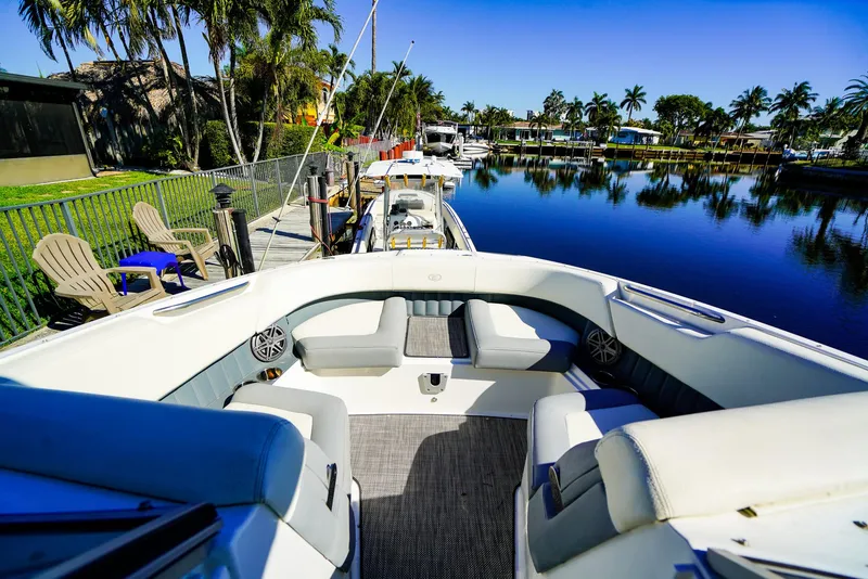 Slide: The Image of 2019 Cobalt 23SC boat docked by a serene waterfront with palm trees. - 16