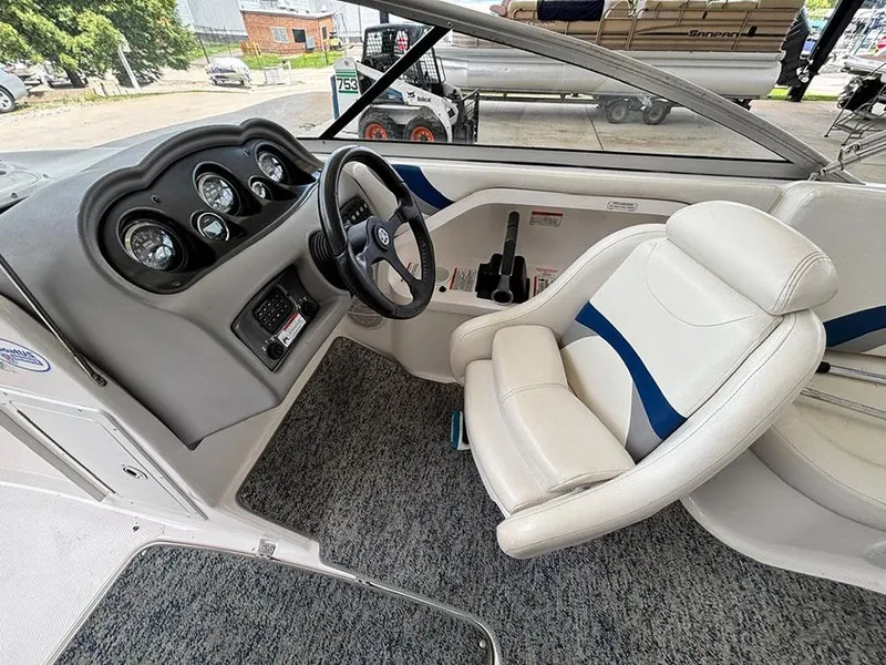 Slide: The Image of 2004 Yamaha Boats 230 SX cockpit with steering wheel and gauges, featuring white and blue seating. - 11