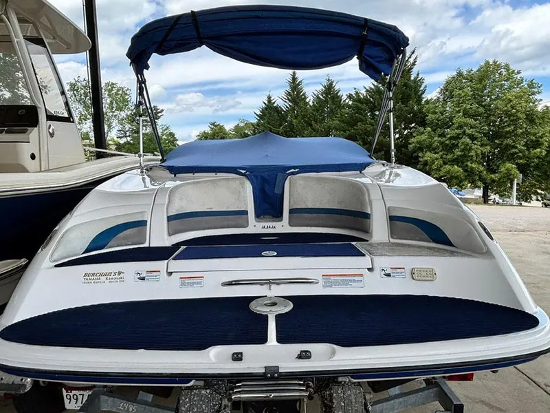 Slide: The Image of 2004 Yamaha Boats 230 SX with blue canopy, docked outdoors. - 3