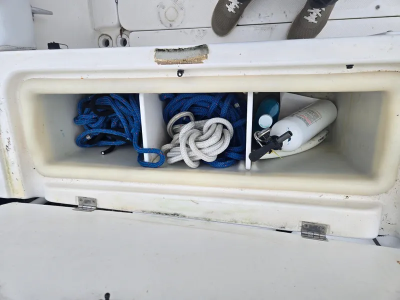 Slide: The Image of Storage compartment on a 1998 Trophy 2503 Center Console with ropes and a fire extinguisher. - 10