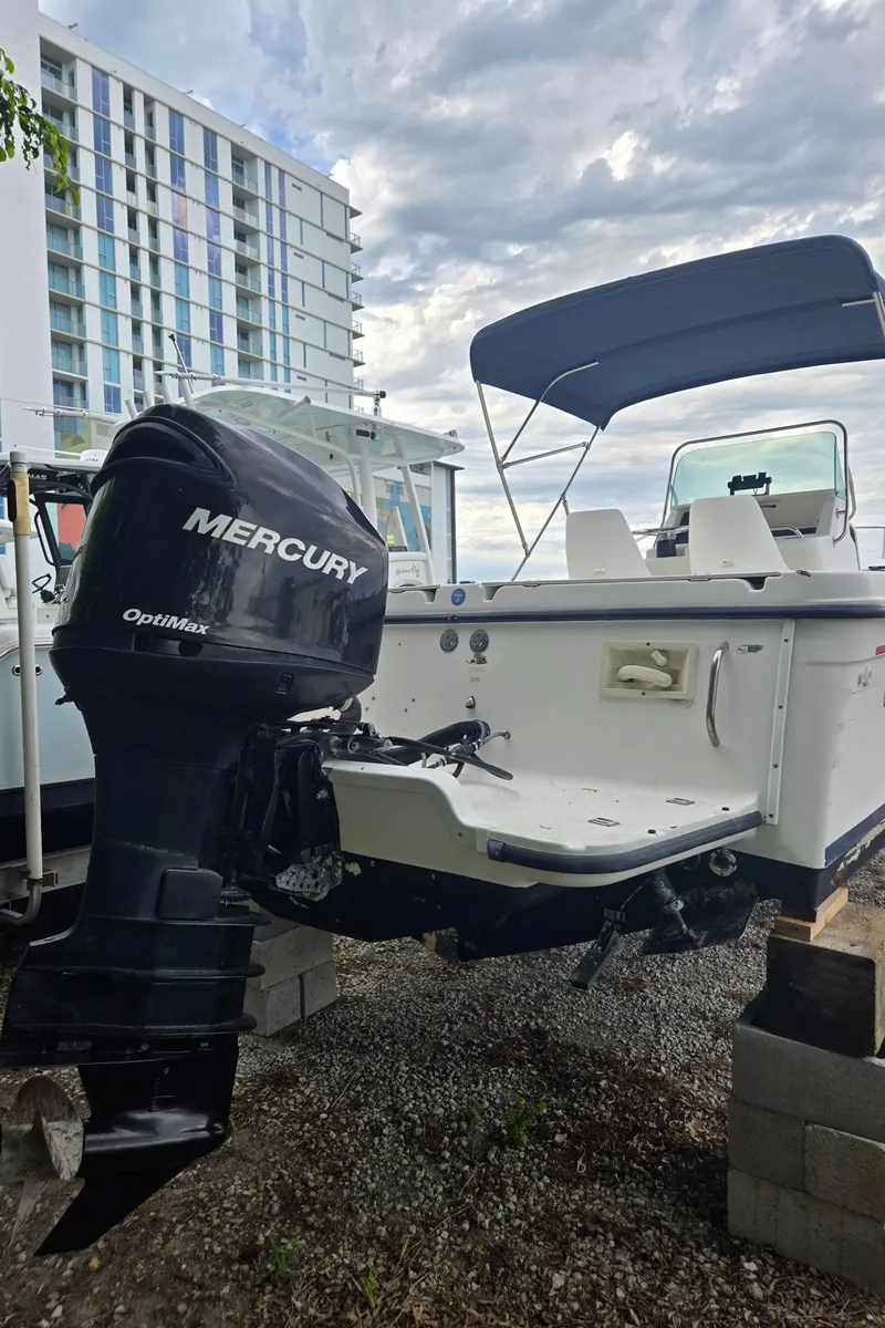 Slide: The Image of 1998 Trophy 2503 Center Console boat with Mercury Optimax engine, docked outdoors. - 17