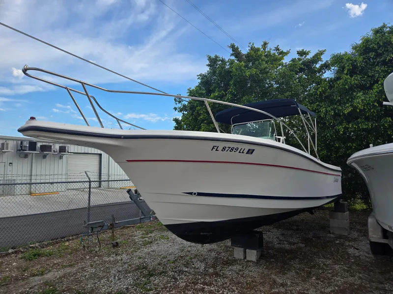 Slide: The Image of 1998 Trophy 2503 Center Console boat on display, parked outdoors. - 2