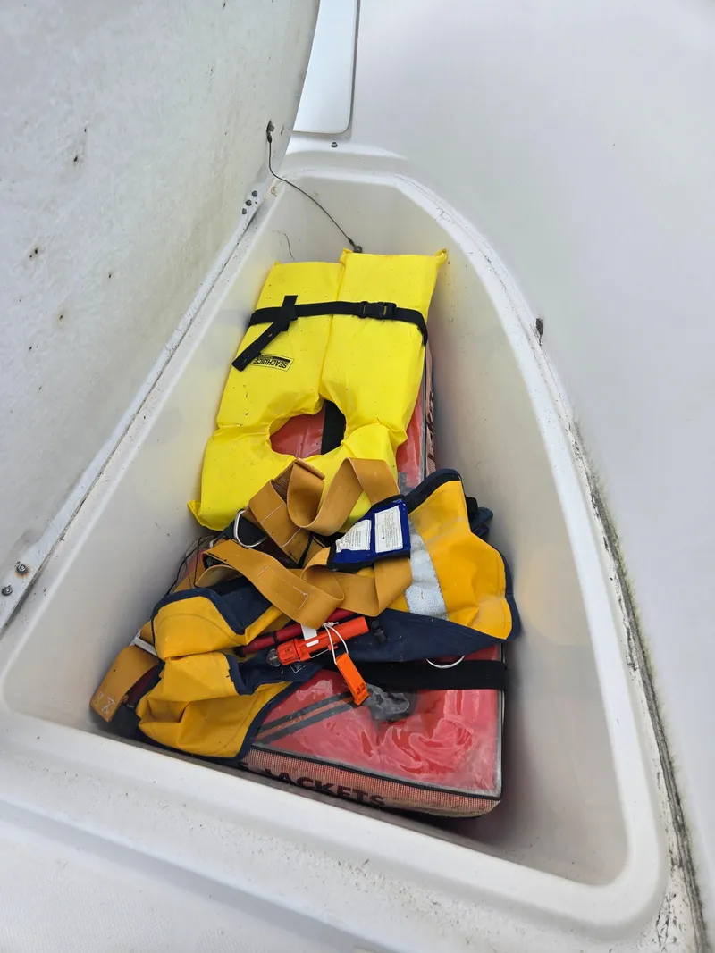 Slide: The Image of Storage compartment with life jackets on a 1998 Trophy 2503 Center Console boat. - 8