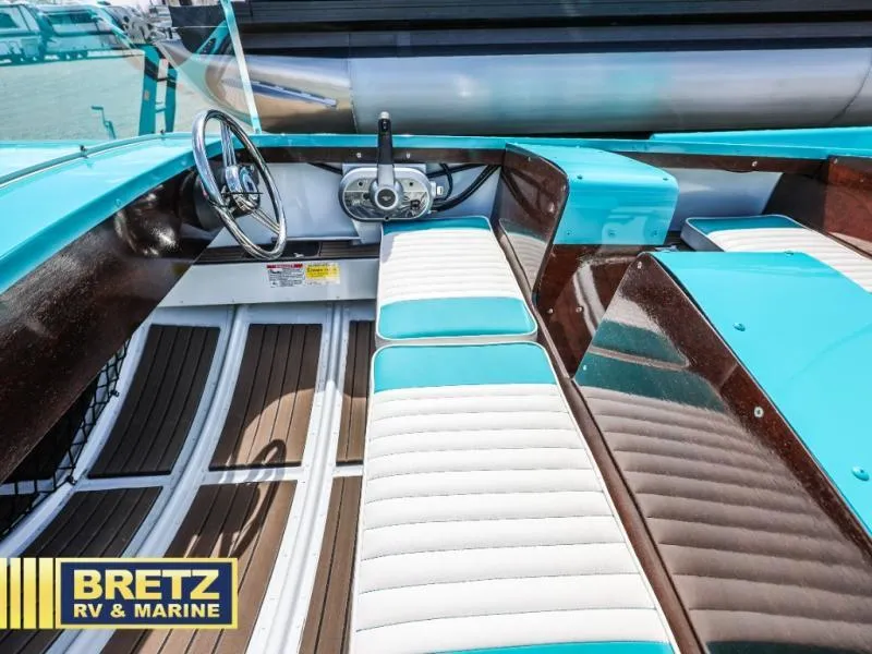 Slide: The Image of 2025 Starcraft 57 SKI CHAMP boat interior with turquoise and white seating, wooden accents. - 10
