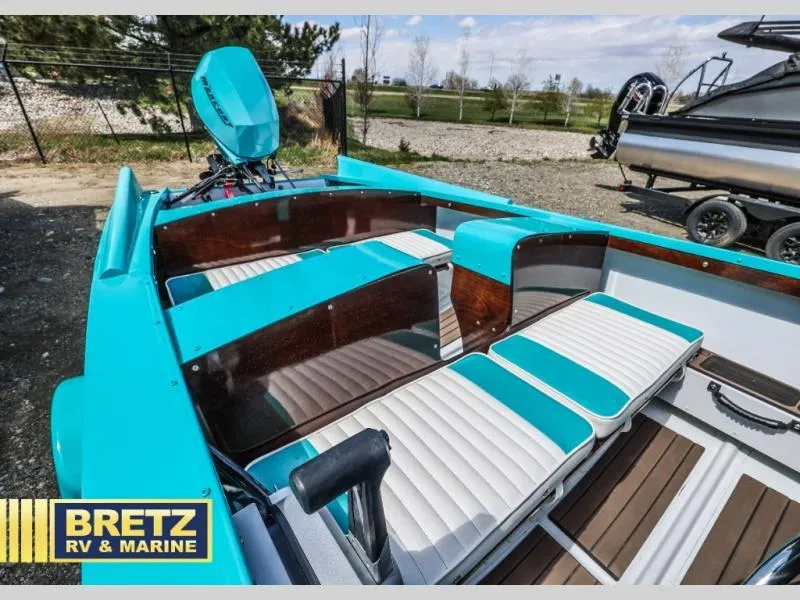 Slide: The Image of 2025 Starcraft 57 SKI CHAMP boat interior with teal and white seating, displayed at Bretz RV & Marine. - 15
