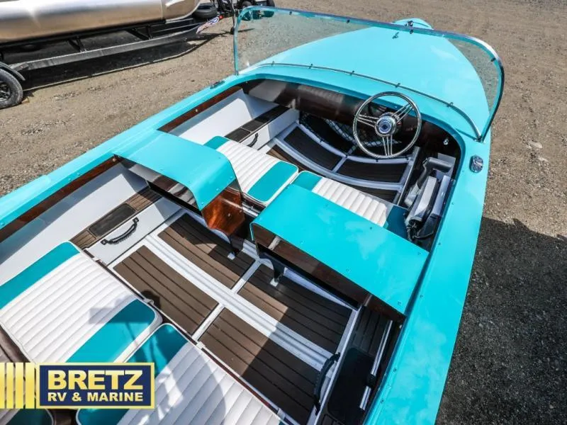 Slide: The Image of 2025 Starcraft 57 SKI CHAMP boat with turquoise exterior and white seating, displayed at Bretz RV & Marine. - 16