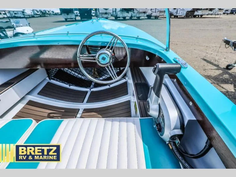 Slide: The Image of 2025 Starcraft 57 SKI CHAMP boat interior with turquoise and white seating, steering wheel, and controls. - 17