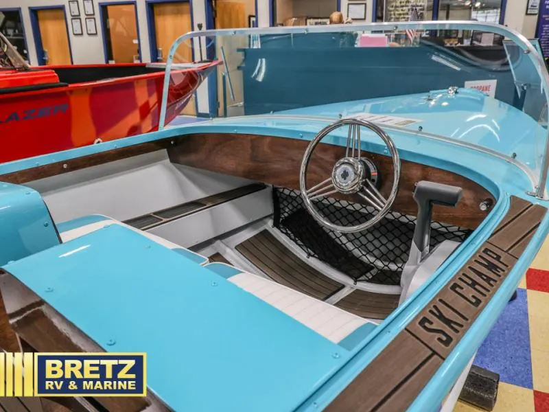 Slide: The Image of 2025 Starcraft 57 SKI CHAMP boat interior with blue and wood accents at Bretz RV & Marine. - 7