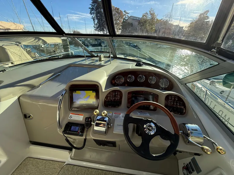 Slide: The Image of 2007 Sea Ray 340 Sundancer helm with navigation controls and steering wheel, docked at marina. - 19