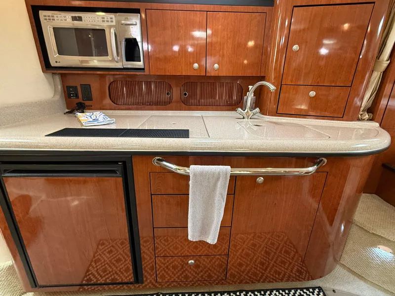 Slide: The Image of Luxurious 2007 Sea Ray 340 Sundancer yacht kitchen with wood cabinetry and modern appliances. - 22