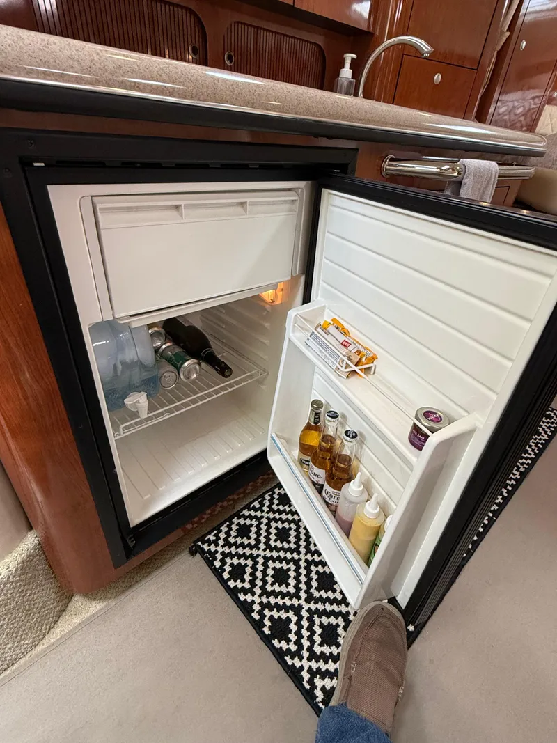 Slide: The Image of Open mini fridge in 2007 Sea Ray 340 Sundancer yacht, stocked with beverages and condiments. - 23